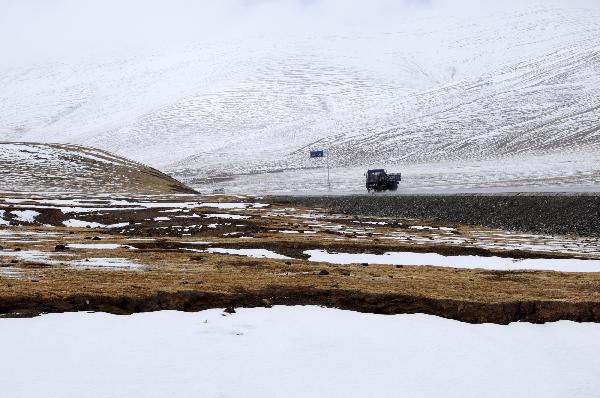 A truck runs against the snow on the road in quake-hit Yushu Tibetan Autonomous Prefecture of northwest China's Qinghai Province, on May 13, 2010.