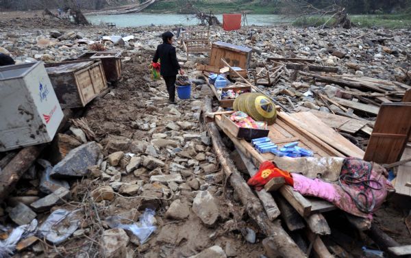 A villager prepares to clean clothes after a flood in Zhuxi village of Xupu County in Huaihua City, central China's Hunan Province, May 16, 2010.