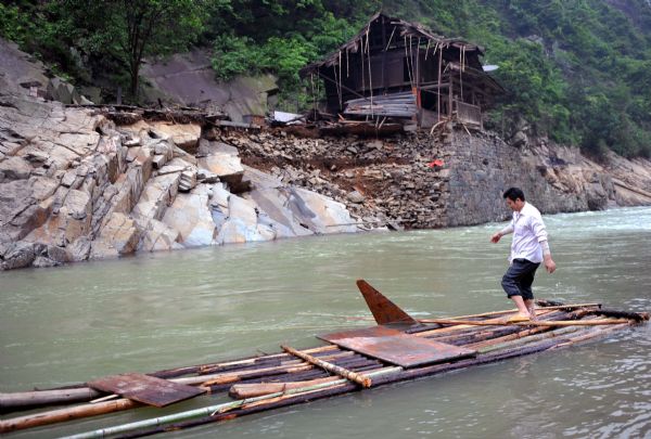 Residents make a raft to cross the river after a flood in Zhuxi village of Xupu County in Huaihua City, central China's Hunan Province, May 16, 2010. 