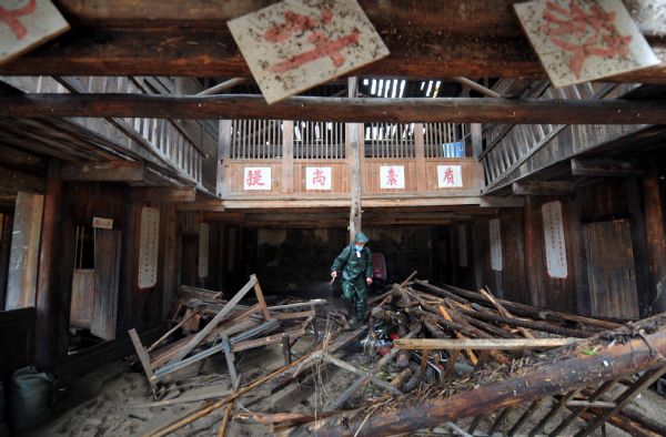 A staff member of the government's epidemic prevention department works to disinfect a school after a flood in Zhuxi village of Xupu County in Huaihua City, central China's Hunan Province, May 16, 2010. 