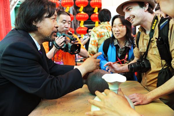 Matt Hansen (R) from America learns the facture of porcelain of ancient China's Ding Kiln, originated in the late Tang Dynasty (618-907) and ended in the Yuan Dynasty (1271-1368), which located in northern China's Hebei Province, in Shanghai of China, May 15, 2010. 