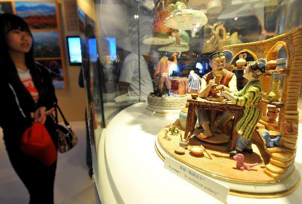 A visitor admires a pottery statue at the Uzbekistan Pavilion in the World Expo park in Shanghai, east China, May 10, 2010. 