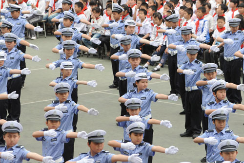 Children practise routines while dressed in traffic police uniforms in Zhengzhou, Henan Province May 17, 2010.