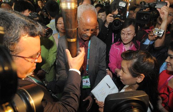 Nadir Merah (L, front), rotating Curator of the Africa Joint Pavilion and Africa Union commissioner general for the World Expo, greets Shanghai citizen Zhang Gennan (R, front), the 1 millionth visitor to the Africa Joint Pavilion with a crosier in World Expo park in Shanghai, May 19, 2010. Visitors to the Africa Joint Pavilion reached 1 million Wednesday.