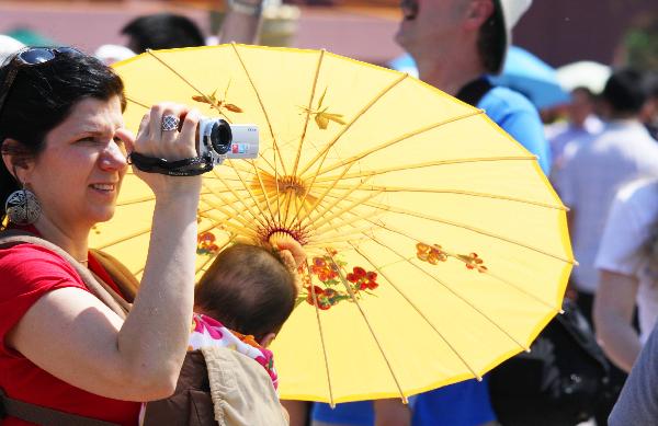 A foreign tourist tours the Tian'anmen Square in Beijing, capital of China, May 19, 2010. A heat wave hit some areas of China recently.