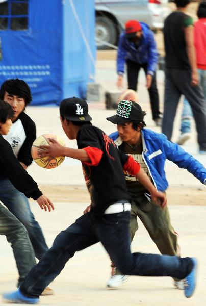 Middle school students of Tibetan ethnic group play basketball near a tent school in Gyegu Town of quake-hit Yushu Tibetan Autonomous Prefecture in northwest China's Qinghai Province, May 19, 2010.