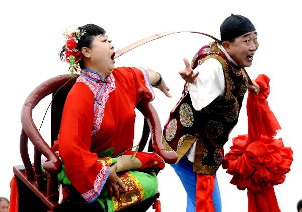 Folk actors from Xiaoyi City of north China&apos;s Shanxi Province stage a Yangko performance at the Shanghai World Expo Park in Shanghai, east China, May 20, 2010.