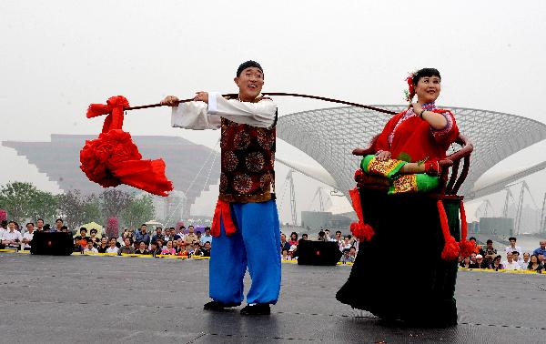 Folk actors from Xiaoyi City of north China&apos;s Shanxi Province stage a Yangko performance at the Shanghai World Expo Park in Shanghai, east China, May 20, 2010.