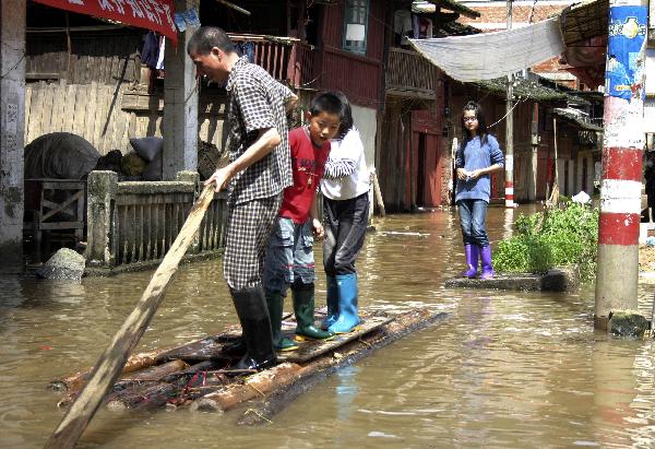 Residents take a raft for moving on a flooded street in Shunchang County of Nanping City, southeast China&apos;s Fujian Province, May 23, 2010. Heavy rain hit the province on May 22 and 23. [Xinhua] 