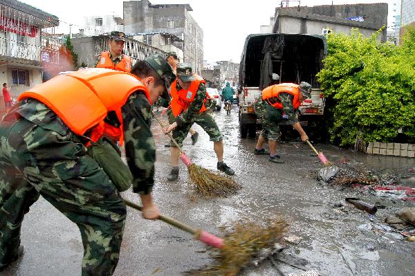 Soldiers clear a street in Xiamen, southeast China&apos;s Fujian Province, May 23, 2010. Heavy rain hit the province on May 22 and 23. [Xinhua] 