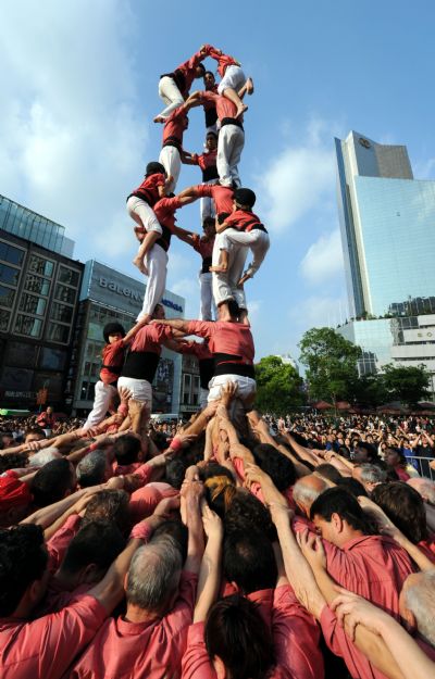 Performers from Spain stack themselves up during the Castell (means castle in Catalan) performance in the Nanjing Pedestrian Street of Shanghai, east China, May 23, 2010. The Castell performance, a traditional folk celebration in Catalonia of Spain, will also be shown in the Expo Park from May 24 to 30.