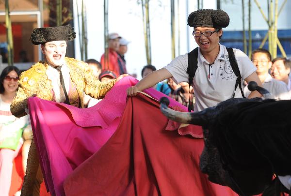 A tourist attends a bullfight interactive game at Madrid Pavilion in the Urban Best Practices Area (UBPA) in the World Expo Park in Shanghai, east China, May 24, 2010.