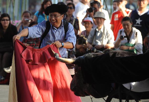 A tourist attends a bullfight interactive game at Madrid Pavilion in the Urban Best Practices Area (UBPA) in the World Expo Park in Shanghai, east China, May 24, 2010.