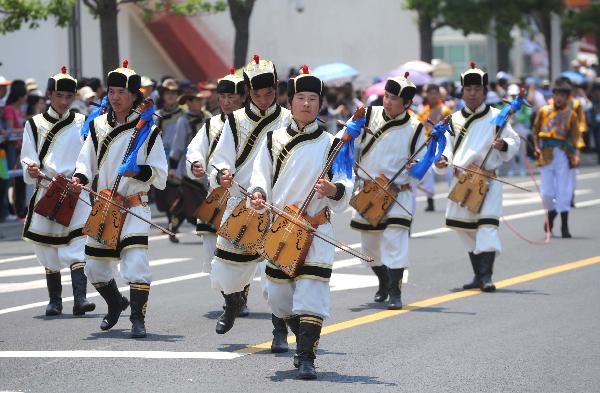 Actors play stringed instrument during a parade at the World Expo Park in Shanghai, east China, May 24, 2010.