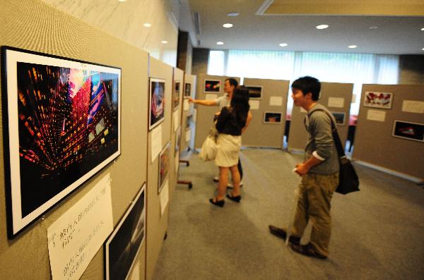 Students of Waseda University watch photos featuring the World Expo 2010 during a photo exhibition sponsored by Chinese Students Association at Waseda University in Tokyo, May 26, 2010.