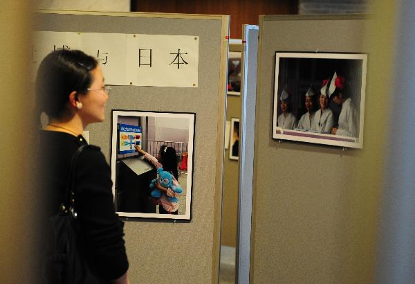 A student of Waseda University watches photos featuring the World Expo 2010 during a photo exhibition sponsored by Chinese Students Association at Waseda University in Tokyo, May 26, 2010.