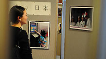 A student of Waseda University watches photos featuring the World Expo 2010 during a photo exhibition sponsored by Chinese Students Association at Waseda University in Tokyo, May 26, 2010.