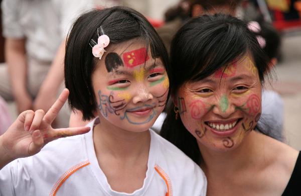 A girl and her mother show colored patterns drawn on their faces in Nanjing, capital of east China's Jiangsu Province, May 29, 2010. 