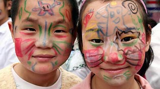 Children show colored patterns drawn on their faces in Nanjing, capital of east China's Jiangsu Province, May 29, 2010.