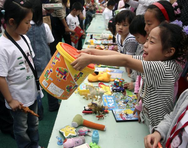 A girl sells her toy at a barter fair held in a kindergarten in Wuxi City, east China's Jiangsu Province, May 29, 2010. 