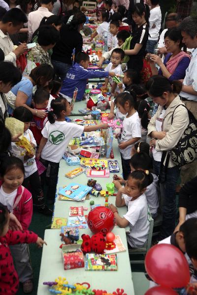 Children exchange their articles at a barter fair held in a kindergarten in Wuxi City, east China's Jiangsu Province, May 29, 2010.