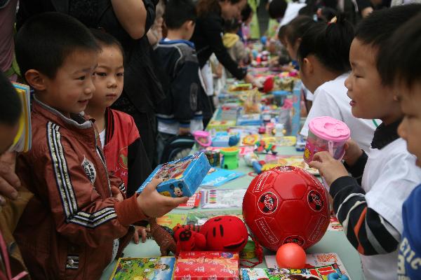 Children exchange their articles at a barter fair held in a kindergarten in Wuxi City, east China's Jiangsu Province, May 29, 2010.