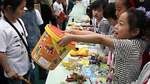 A girl sells her toy at a barter fair held in a kindergarten in Wuxi City, east China's Jiangsu Province, May 29, 2010.