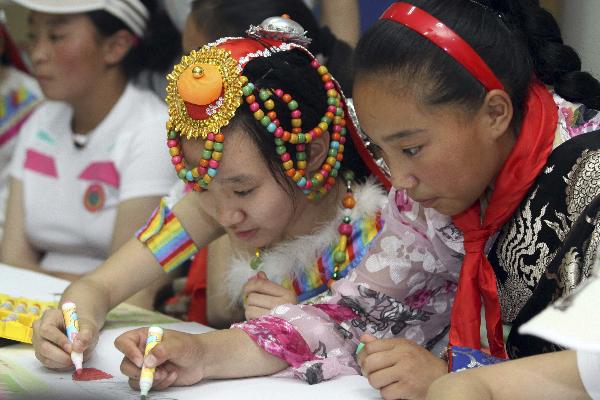 Daixi Qiuzhan (R) from northwest China&apos;s quake-hit Yushu Prefecture draws picutre with Wang Shiran of Tianjin at the youth activity center of Tianjin, north China, May 30, 2010. 