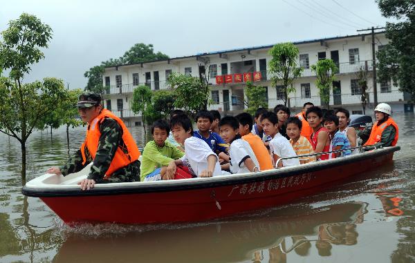 Rescuers transfer the students by lifeboat who are trapped at school in Laibin City, south China's Guangxi Zhuang Autonomous Region, June 1, 2010, due to the continuing severe rain and storm.