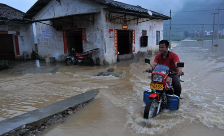 A man rides motorcycle on a flooded street in Laibin City, south China's Guangxi Zhuang Autonomous Region, June 1, 2010.