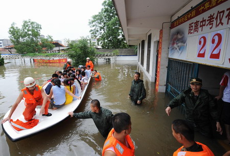 Firefighters help evacuate students who are trapped by flood at a school in Laibin City, south China's Guangxi Zhuang Autonomous Region, June 1, 2010. 