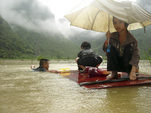 Students are evacuated to safety after flood caused by heavy rain in Hechi, southwest China's Guangxi Zhuang Autonomous Region, June 1, 2010.
