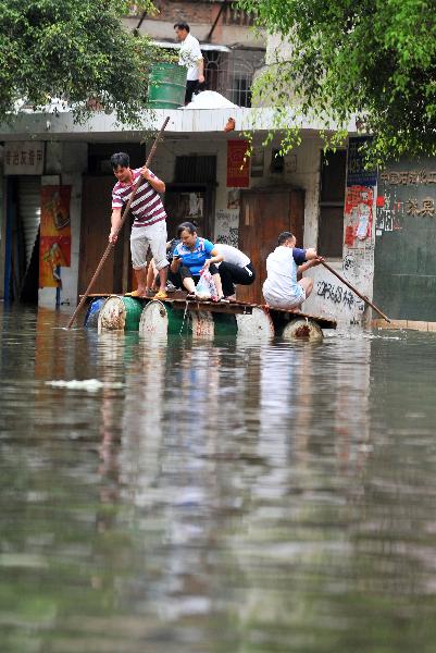 Local residents ride on a self-made boat on a flooded street in Laibin City, southwest China's Guangxi Zhuang Autonomous Region, June 2, 2010. 