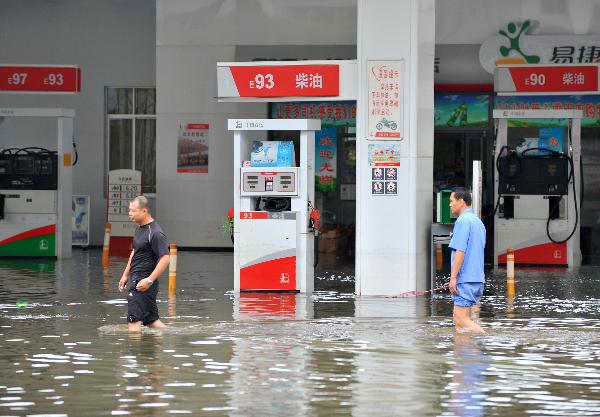 Local residents wade through a flooded street in Laibin City, southwest China's Guangxi Zhuang Autonomous Region, June 2, 2010. Laibin City was battered by heavy rain Monday night and Tuesday. The city center, the worst-hit by the rainstorm, received 439 mm of rainfall, an all-time high. 