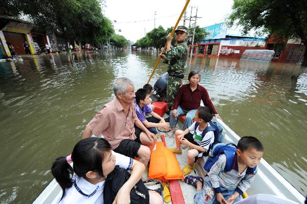 A firefighter transfers trapped residents with a lifeboat on a flooded street in Laibin City, southwest China's Guangxi Zhuang Autonomous Region, June 2, 2010. Laibin City was battered by heavy rain Monday night and Tuesday.