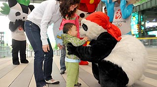 'Kung Fu Panda' plays with a child at the Shanghai Expo Park after the Beijing Week concludes. 18-year-old Sun Cheng, the panda player, was an actor for the Beijing Week (May 4-8) at the Expo.