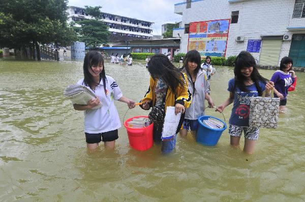 Students of grade 3 walk in the flood at the Second Senior High School in Yao Ethnic Autonomous County of Du'an in south China's Guangxi Zhuang Autonomous Region, June 2, 2010. Though the water flooded the campus caused by heavy rains, students who prepared for the coming college entrance examination on June 7 continue their studies.