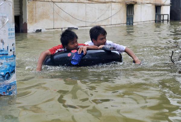 Local residents are seen in flooded Beigeng Township of Xincheng County in south China's Guangxi Zhuang Autonomous Region, June 2, 2010.