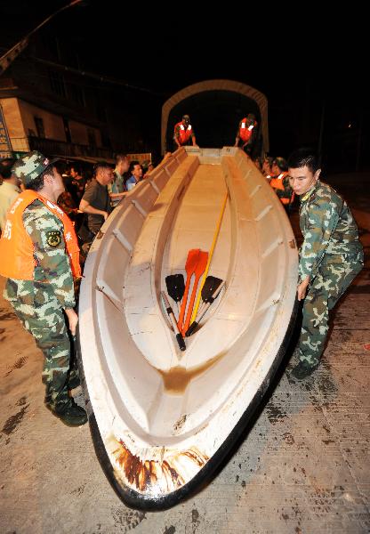 A boat is carried to rescue trapped residents in Laibin, southwest China's Guangxi Zhuang Autonomous Region, on June 2, 2010. 