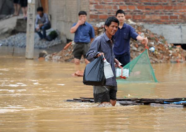 A local wades through floods in Laibin, southwest China's Guangxi Zhuang Autonomous Region, on June 3, 2010.