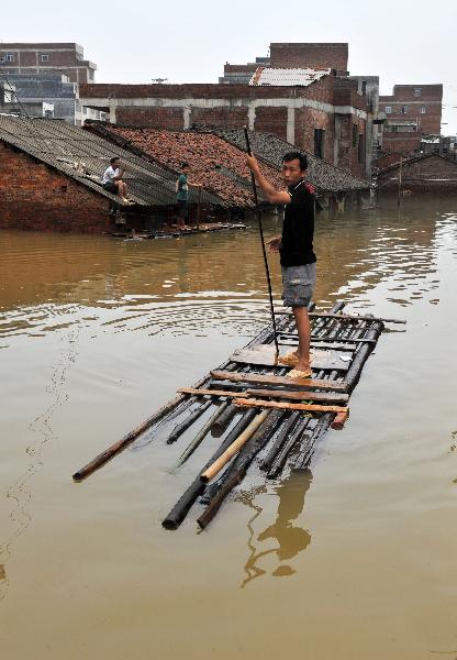 A local resident is seen on a make-shift raft in Laibin, southwest China's Guangxi Zhuang Autonomous Region, on June 3, 2010.