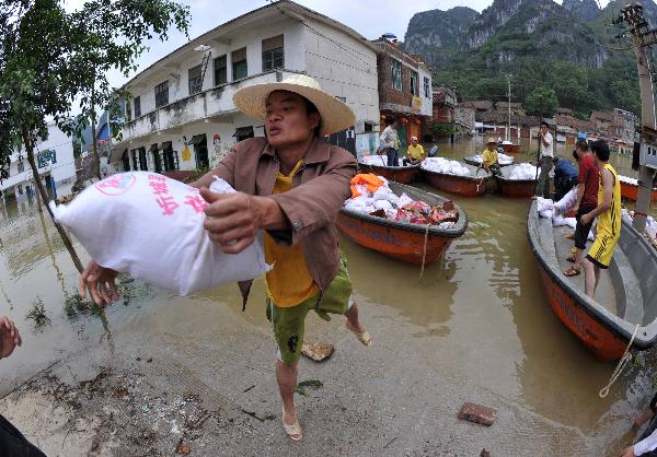 Local residents transport relief supply in Beigeng township, Xincheng County, south China's Guangxi Zhuang Autonomous Region, June 3, 2010. 