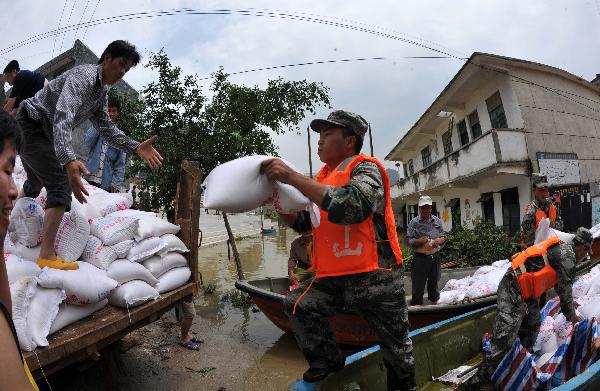 Soldiers and local residents transport relief supply in Beigeng township, Xincheng County, south China's Guangxi Zhuang Autonomous Region, June 3, 2010. 