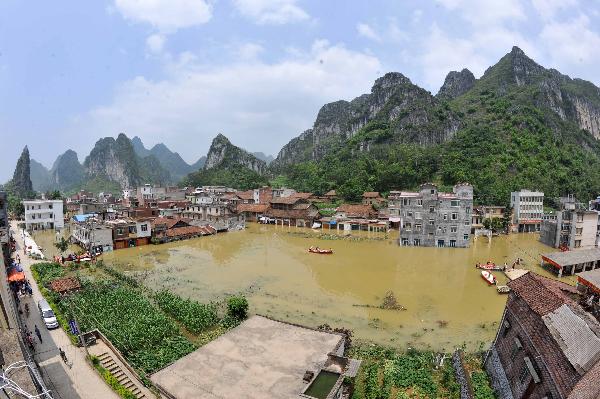 Relief supplies are transported by boats in Beigeng Township, Xincheng County, south China's Guangxi Zhuang Autonomous Region, June 3, 2010. 