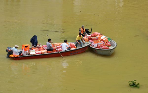 Boats transport relief supplies in Beigeng Township, Xincheng County, south China's Guangxi Zhuang Autonomous Region, June 3, 2010. 