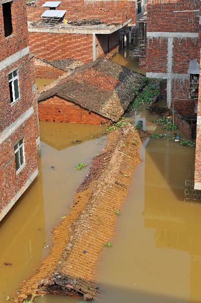 Houses are flooded at Lingwo, Dongshe district, Laibin city, south China&apos;s Guangxi Zhuang Autonomous Region, June 4, 2010. Some 1,700 residents in Lingwo were still trapped by the flood triggered by heavy rain since Wednesday in Guangxi. 