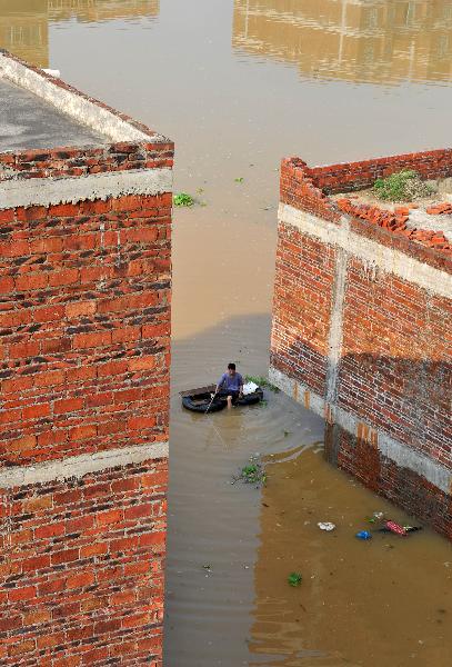 A local resident fishes on a flooded street at Lingwo, Dongshe district, Laibin city, south China&apos;s Guangxi Zhuang Autonomous Region, June 4, 2010. Some 1,700 residents in Lingwo were still trapped by the flood triggered by heavy rain since Wednesday in Guangxi. 