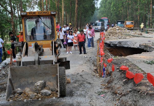 A bulldozer works at a damaged road in Qiaogong Village, Xingbin District of Laibin City, southwest China's Guangxi Zhuang Autonomous Region, June 5, 2010. 