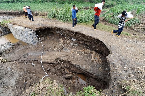 Photo taken on June 6, 2010 show a road damaged by rainstorms in Shang'e Village of Huangmao Township in Wuxuan Countyship of Laibin City, southwest China's Guangxi Zhuang Autonomous Region.