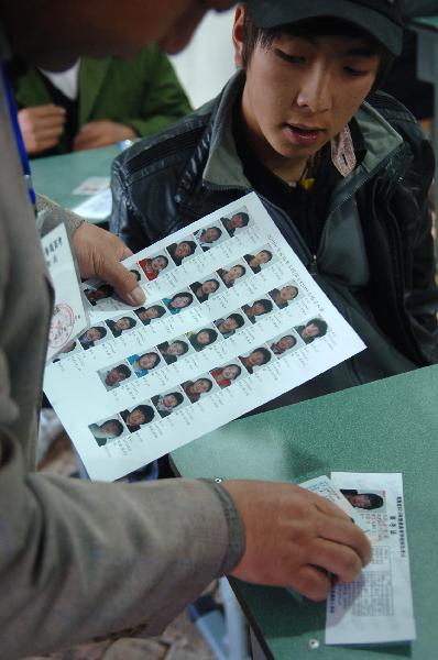A staff member checks the admission card of an examinee before the college entrance exam, or Gaokao, in the quake-hit Gyegu Town of the Tibetan Autonomous Prefecture of Yushu, northwest China's Qinghai Province, June 7, 2010. 
